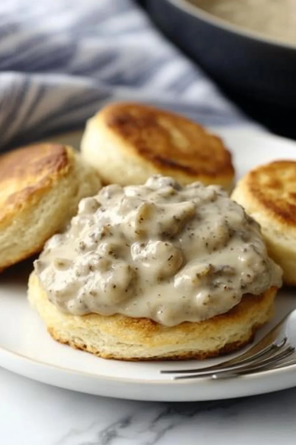 Buttermilch-Biscuits mit cremiger Wurstsoße, serviert auf einem Teller.