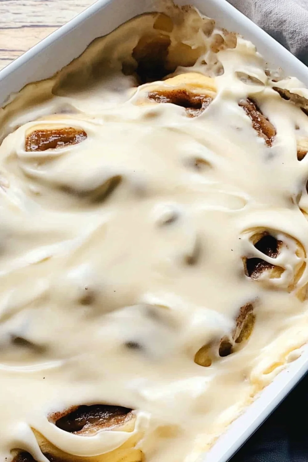 Nahaufnahme von frisch gebackenen Zimtschnecken, die mit einer reichhaltigen Glasur überzogen sind und ihre weichen, flauschigen Schichten zeigen.