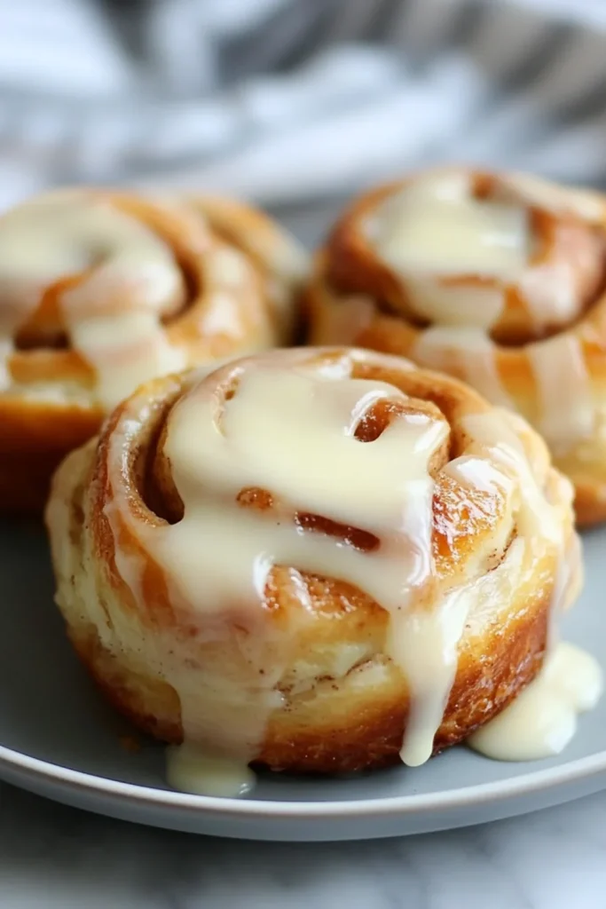 Nahaufnahme von frisch gebackenen Zimtschnecken, die mit einer reichhaltigen Glasur überzogen sind und ihre weichen, flauschigen Schichten zeigen.
